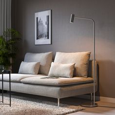 a living room scene with focus on the couch and floor lamp in the foreground