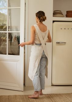 a woman standing in front of an open door with her back turned to the camera