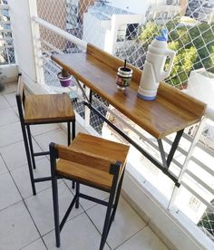 three wooden stools sitting on top of a tiled floor next to a balcony railing