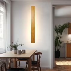 a wooden table sitting under a light fixture in a kitchen next to a dining room