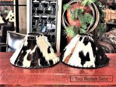 two black and white lampshades sitting on top of a wooden table