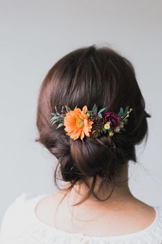 a woman with flowers in her hair is wearing a flower headpiece on her back