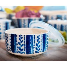 a blue and white bowl sitting on top of a wooden table next to other bowls