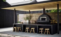 an outdoor kitchen with bar stools and table