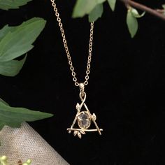 Our Fae Collection was inspired by childhood days spent in the woods talking to the trees and feeling at home with the woodland spirits. Our Fae Necklace is a delicate branch triangle holding a genuine quartz crystal at its center. Brass plated in goldtone. 16" length chain with a 3" extension for adjustable length. Each crystal will be white but with variation of clarity and occlusion due to natural variation in the mineral and no two will be alike. All orders over $50 ship for free within the Feeling At Home, The Fae, Childhood Days, Jewelry Lookbook, Butterfly Jewelry, Pretty Jewellery, In The Woods, Cute Jewelry, Beautiful Necklaces