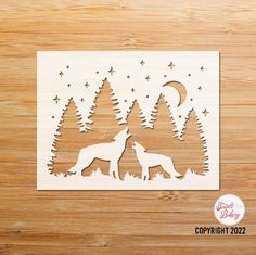 a cutout of two wolfs in the woods with stars and moon above them