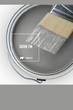 a paint can with a brush in it and the words shark fin painted on it