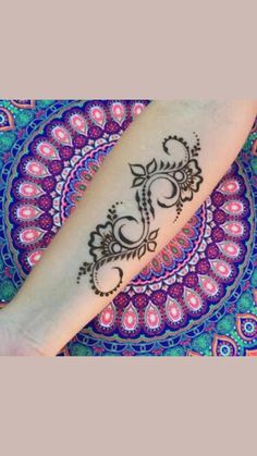 a woman's arm with a henna tattoo on it