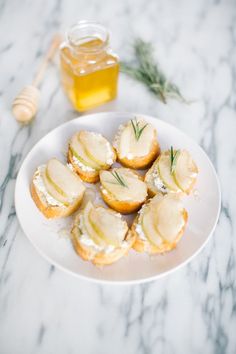 small crackers on a plate next to a jar of honey