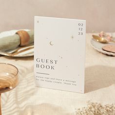 a guest book sitting on top of a table next to other plates and bowls with silverware