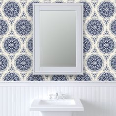 a white sink sitting under a bathroom mirror next to a wall mounted faucet