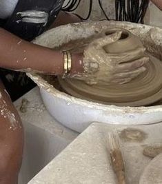 a woman is making clay on a potter's wheel