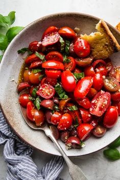 a white bowl filled with tomatoes and bread