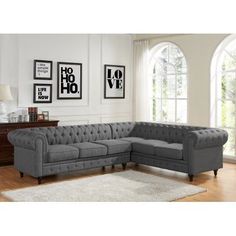 a living room with a gray couch and pictures on the wall above it, along with a white rug