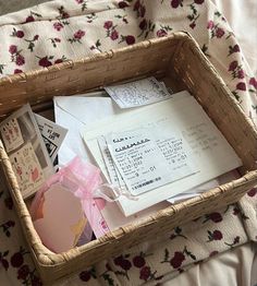 a wicker basket filled with lots of mail and papers on top of a bed