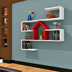 two white shelves with red houses on them in a living room next to a blue wall