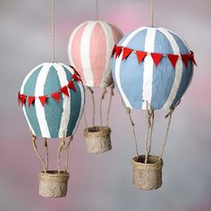 three hot air balloons are hanging from twine