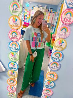 a woman taking a selfie in front of a mirror with stickers on it