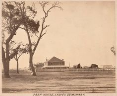 an old black and white photo of a house in the middle of a field with trees