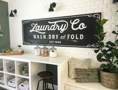 the laundry co wash dry and fold sign is hanging on the wall next to a white shelf