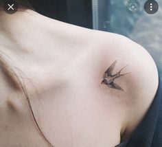 a small tattoo on the shoulder of a woman's upper arm, with a bird flying above it