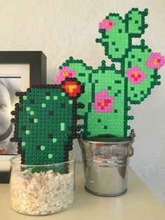 a cactus plant made out of legos sitting on top of a table next to a potted plant