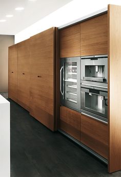 a kitchen with wooden cabinets and stainless steel ovens