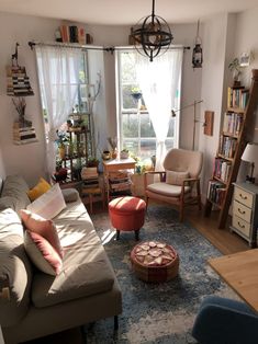 a living room filled with furniture and lots of books on the shelves next to a window