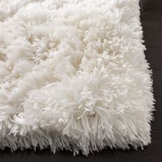 a white shaggy rug on a wooden floor