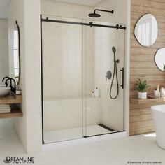 a bathroom with a walk in shower next to a white bath tub and wooden wall