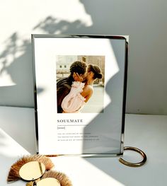 an image of a couple kissing in front of a photo frame and keychain