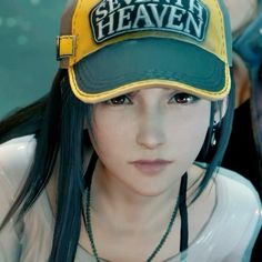 a woman with long black hair wearing a green and yellow hat that says seventh heaven