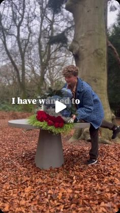 a man sitting on top of a bench next to a flower pot filled with flowers