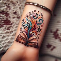 a woman's arm with an open book tattoo on her left wrist and colorful swirls coming out of the book