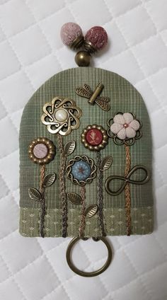 a close up of a purse on a bed with buttons and other things attached to it