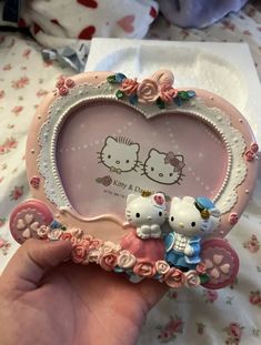 a hello kitty photo frame with two little kittens in the center and pink roses around it