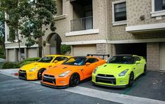 three different colored cars parked in front of a building