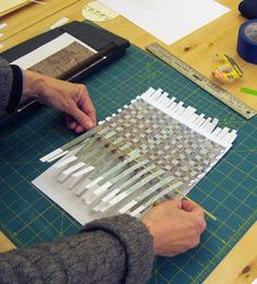 a person working on some type of art project with scissors and paper cutting it out