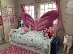 a child's bedroom decorated in pink and blue with stuffed animals on the bed