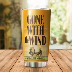 a close up of a cup on a table with the words gone with the wind