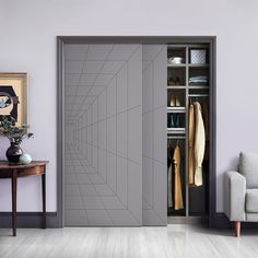 an open closet with clothes and shoes on the shelves next to a white couch in front of a purple wall