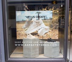 a pair of shoes sitting on top of cement blocks in front of a store window