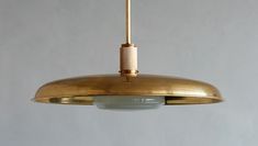 a large brass pendant light hanging from a ceiling