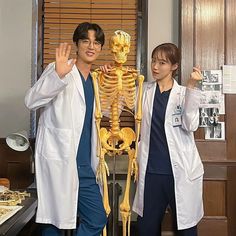 two doctors standing in front of a skeleton