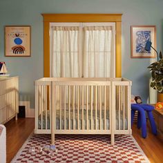 a baby crib in the corner of a room with blue walls and wooden floors