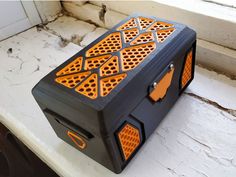 an orange and black box sitting on top of a window sill next to a white door