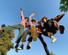 four people jumping in the air with their skateboards