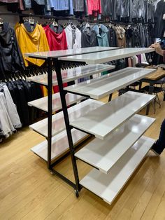 a man is looking at shelves in a clothing store