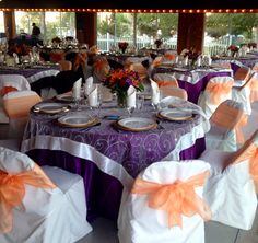 the tables are decorated with orange and white linens