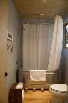 a white toilet sitting next to a bath tub in a bathroom under a shower curtain